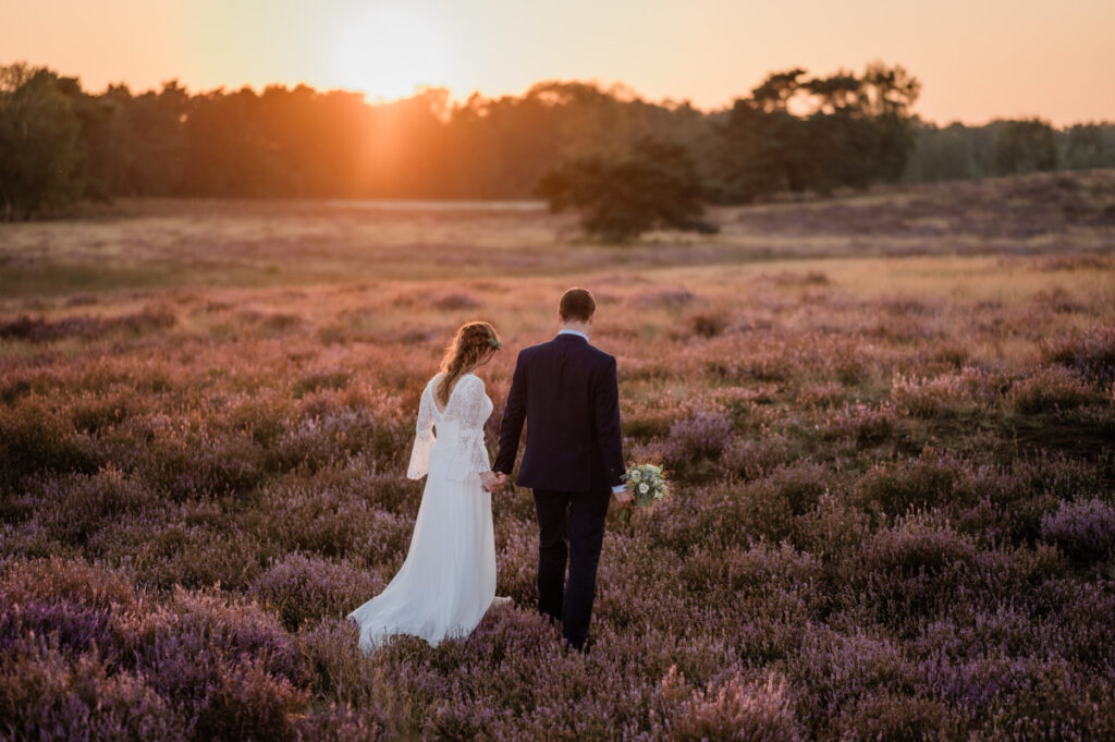 Hochzeitsfotograf Essen fotografiert ein Brautpaar im Sonnenuntergang das spazieren geht