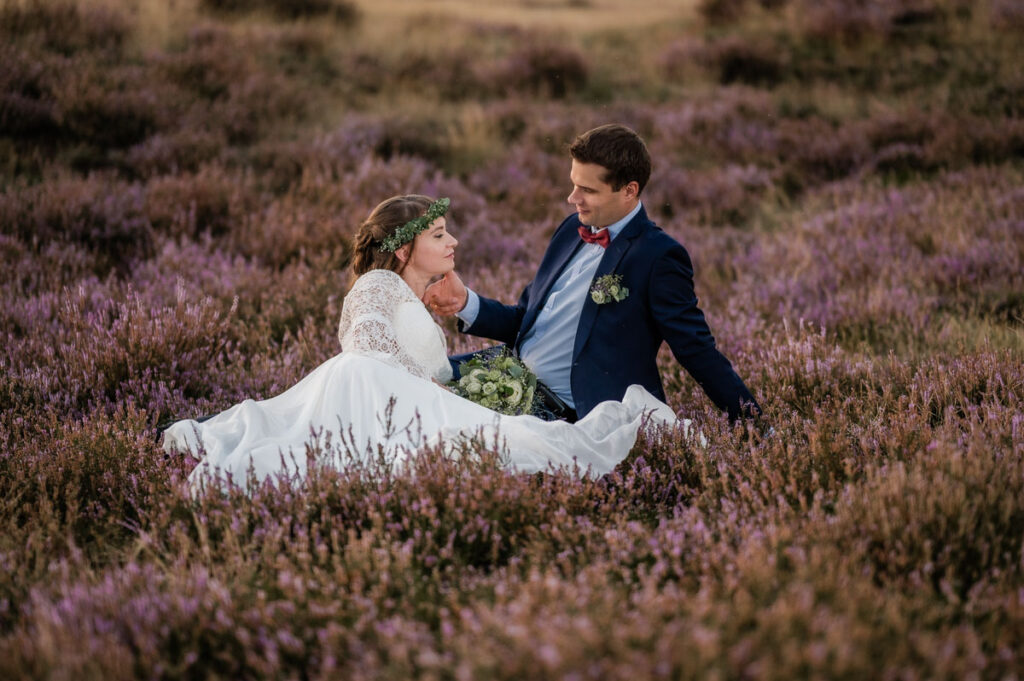 Hochzeitsfotograf Essen fotografiert ein Brautpaar das auf der Wiese sitzt