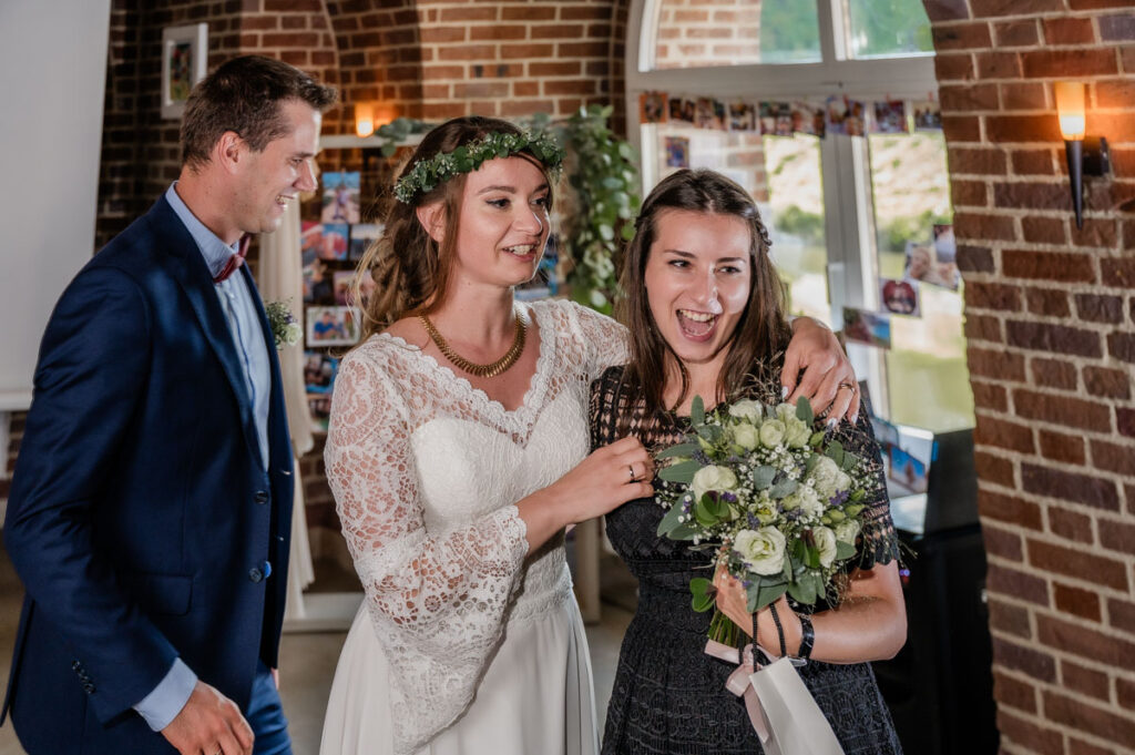 junges Mädchen freut sich im Arm der Braut
