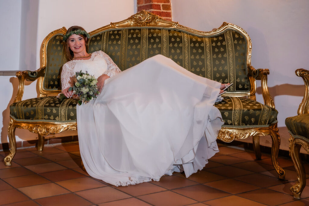 Braut sitzt auf dem Sofa im Schloss Nordkirchen
