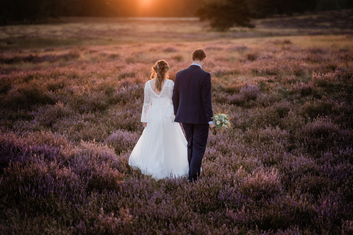 Hochzeitsfotograf Essen fotografiert ein Brautpaar im Sonnenuntergang das spazieren geht
