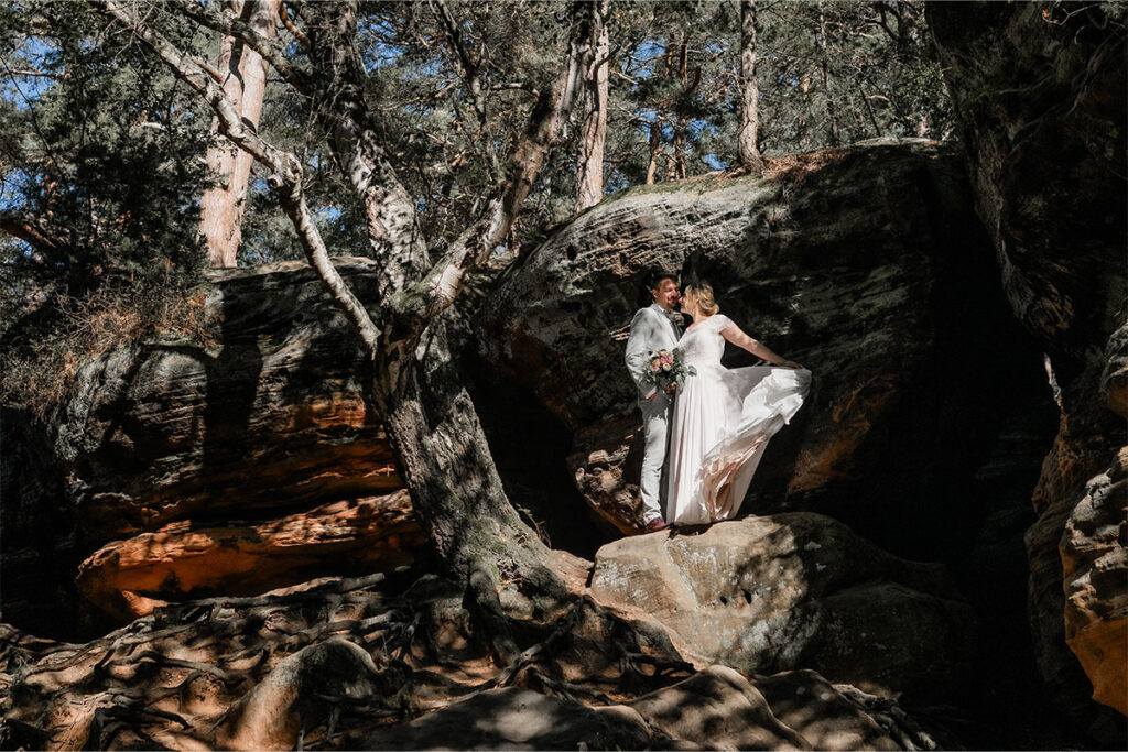 Hochzeitsfotograf Essen fotografiert ein glückliches Brautpaar auf den Felsen im Wald