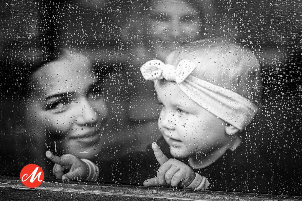Hochzeitsfotograf Essen fotografiert ein Kind das durch ein regnerisches Fenster schaut