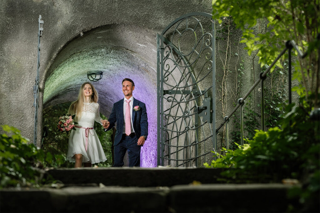 Hochzeitsfotograf Essen fotografiert ein verliebtes Brautpaar das aus einem Tunnel in der Natur rauskommt