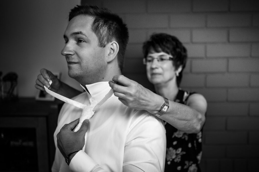 Mutter hilft dem Bräutigam bei der Krawatte