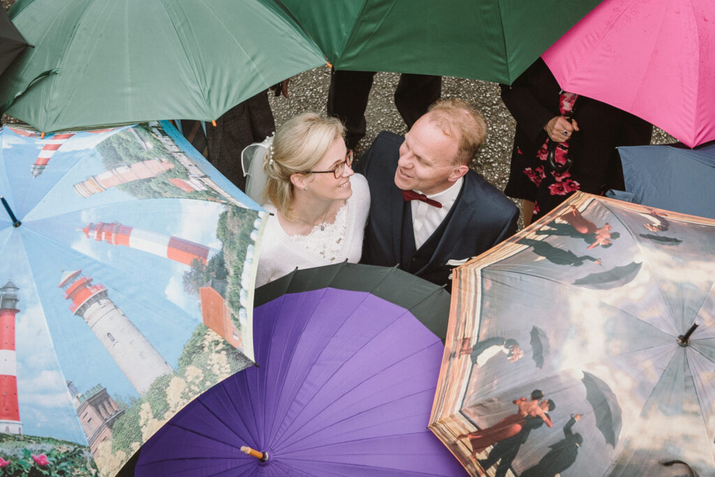 Hochzeitsfotograf Essen fotografiert ein Brautpaar unter Regenschirmen