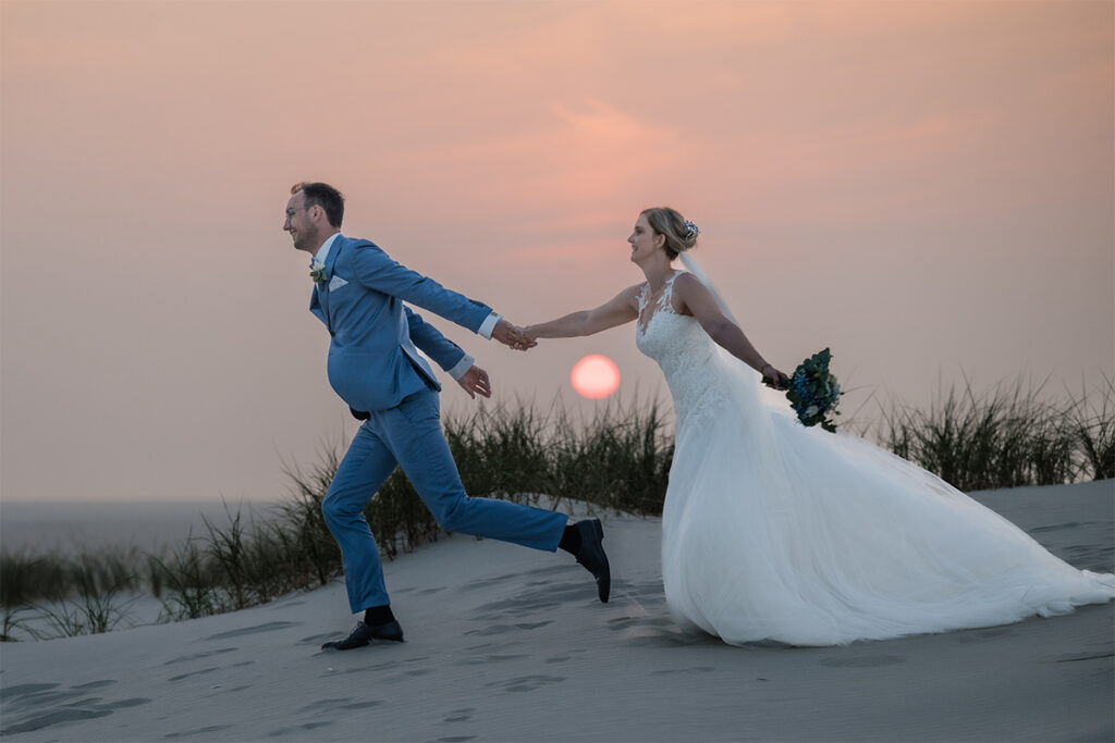 Hochzeitsfotograf Essen fotografiert laufendes Brautpaar am Strand von Amrum