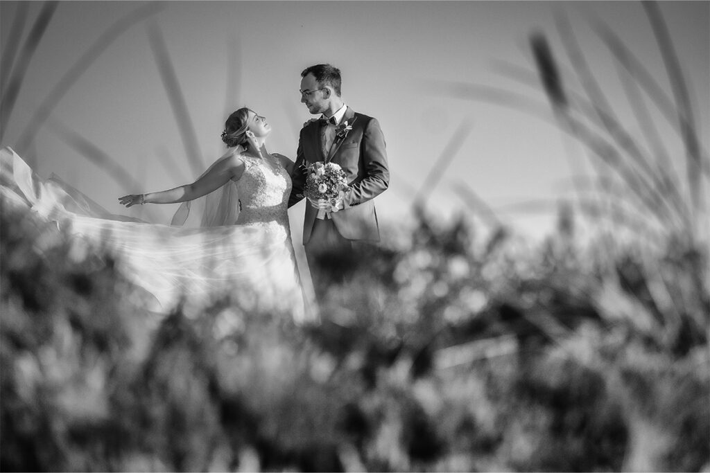 Brautpaar mit Hochzeitskleid im Gras