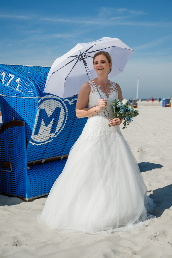 Hochzeitsfotograf Essen fotografiert die Braut mit Sonnenschirm am Strand