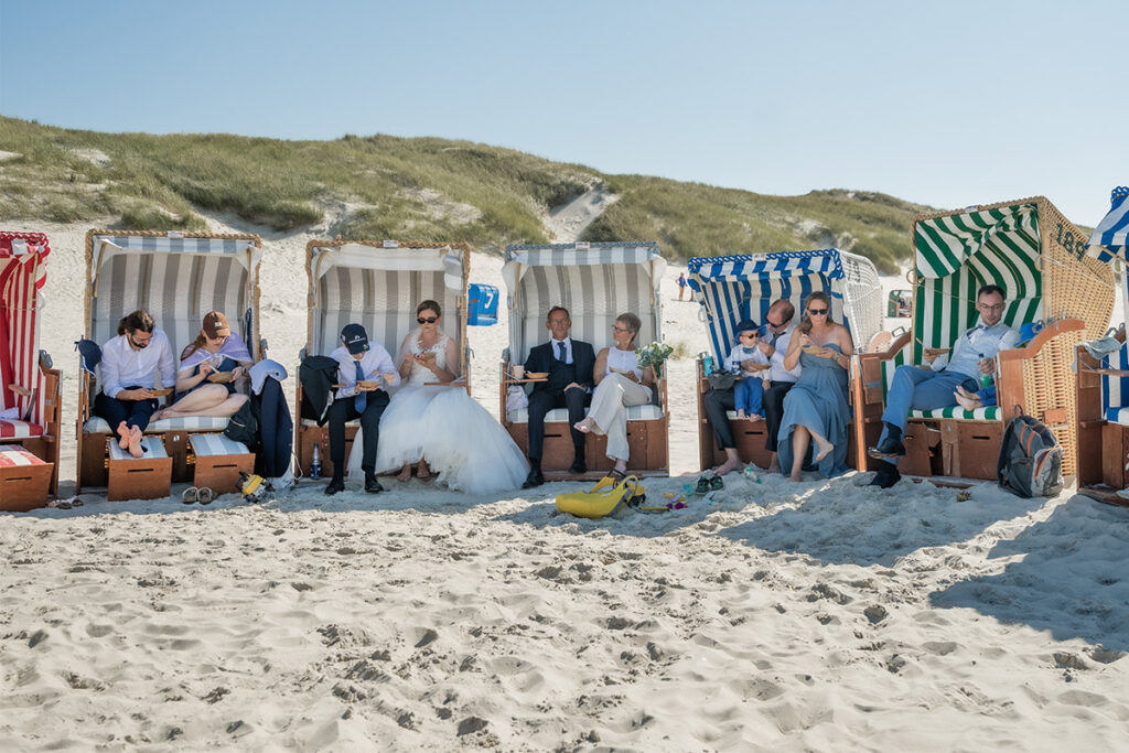 Hochzeitsfotograf Essen fotografiert das Brautpaar mit ihren Freunden im Strandkorb