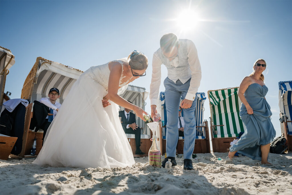 Hochzeitsfotograf Essen fotografiert ein Brautpaar, dass Sand in eine Flasche füllt