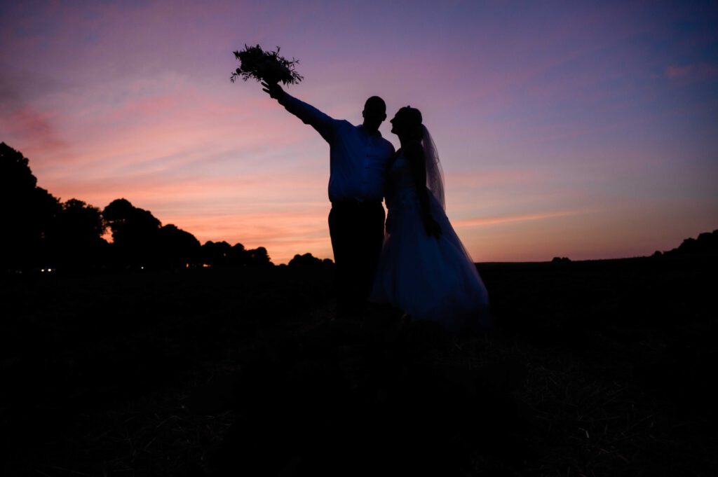 Brautpaar abends auf einem Feld mit Brautstrass