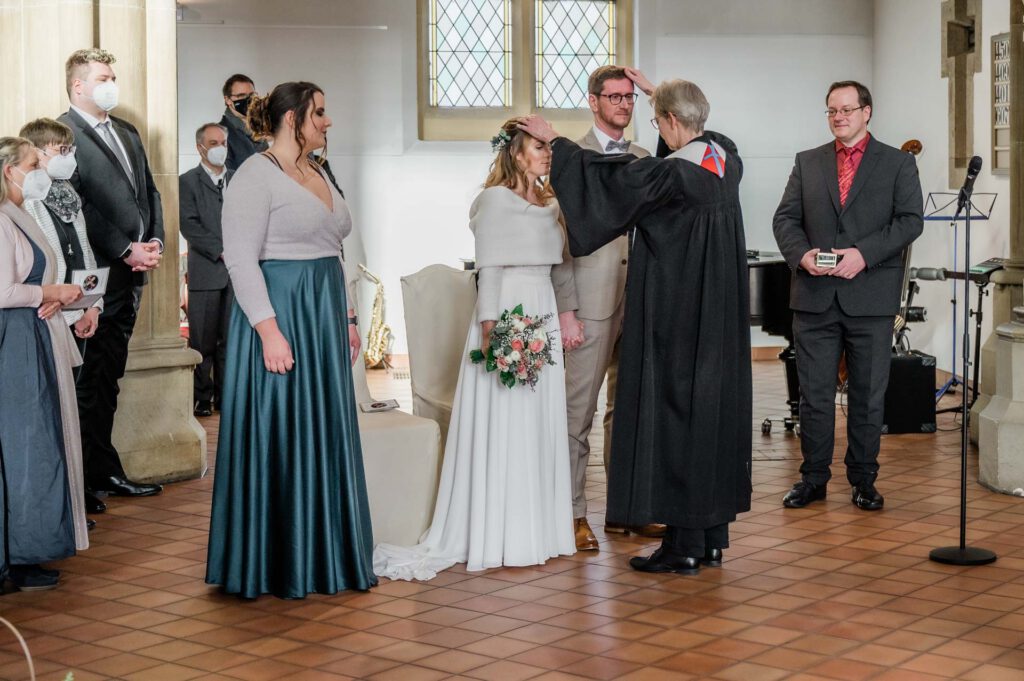 Hochzeitsfotograf Essen fotografiert den Segen in der Kirche mit Brautpaar