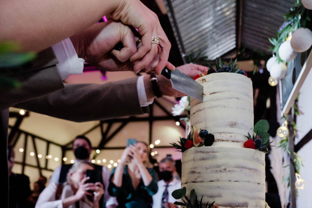 Hochzeitsfotograf Essen fotografiert den Tortenanschnitt auf einer Hochzeitsfeier
