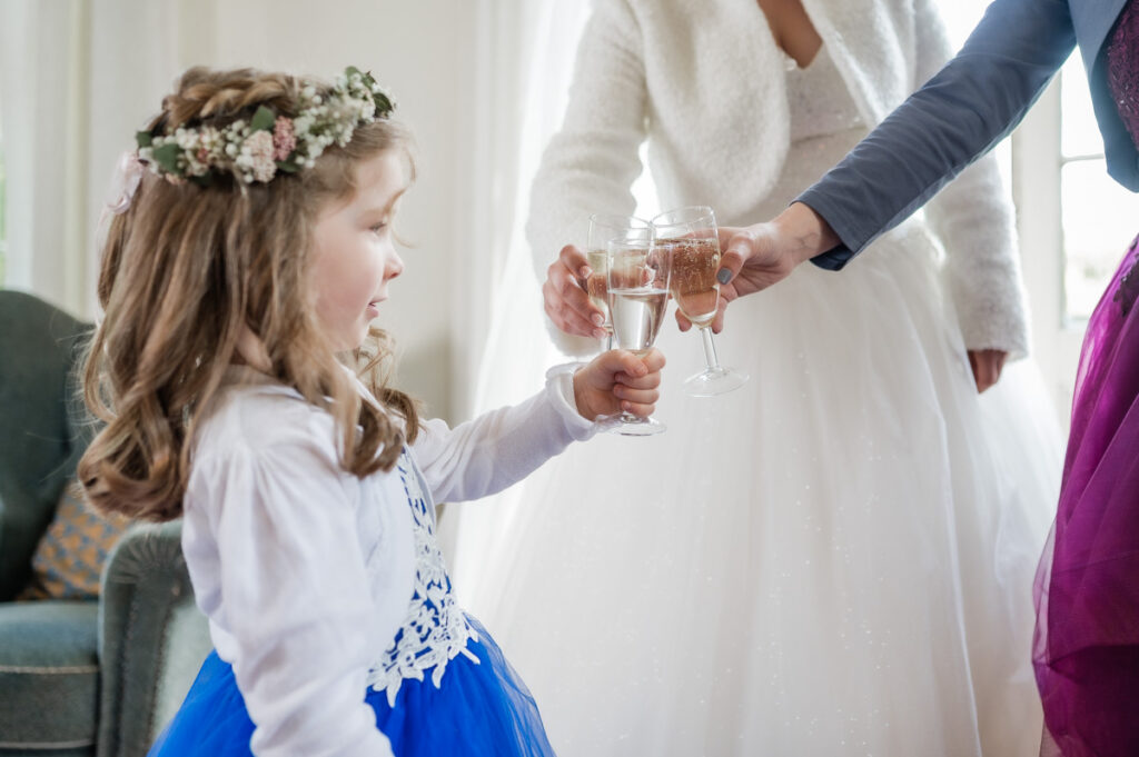 kleines Mädchen stößt mit Sekt an zum Hochzeitstag