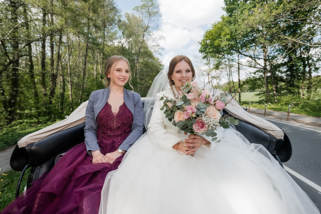 Braut in der Hochzeitskutsche freut sich