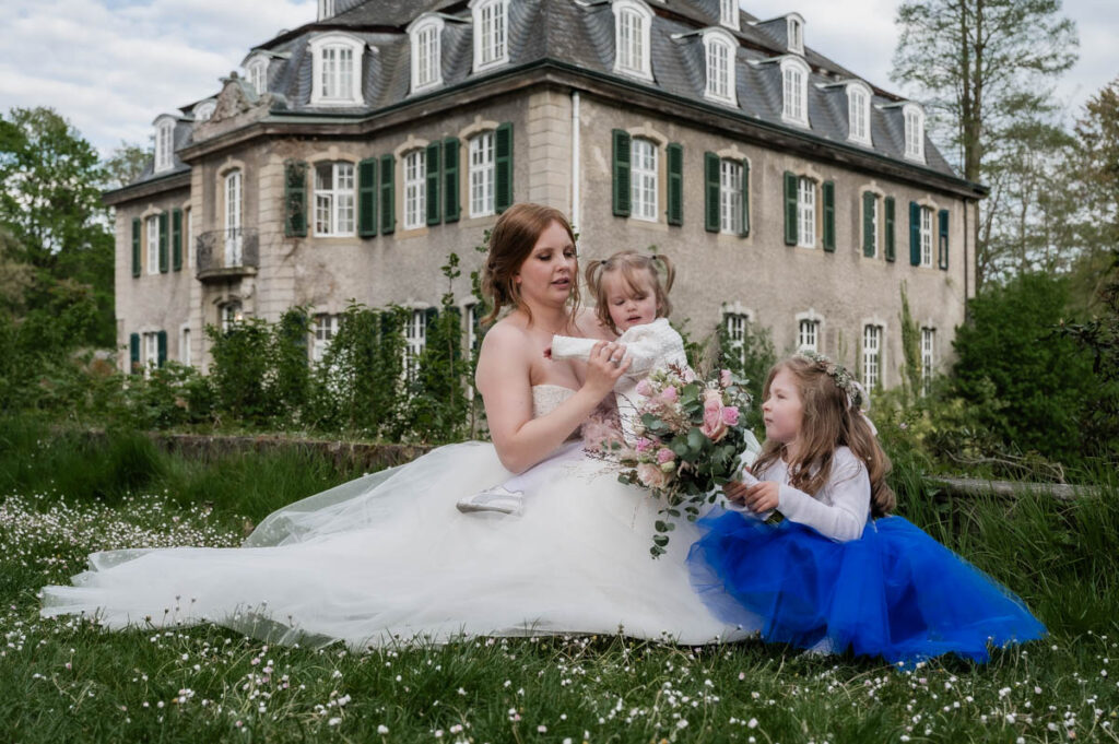 Hochzeitsfotograf Essen fotografiert die Braut mit ihren Kindern vor dem Wasserschloss Hackhausen