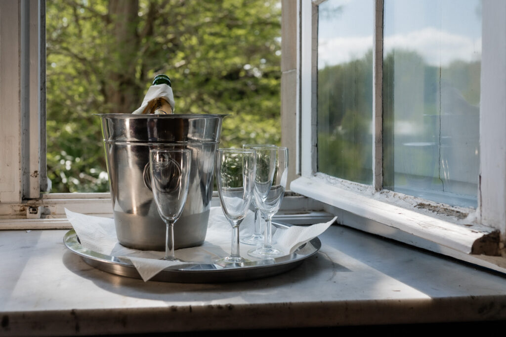 Hochzeitsfotograf Essen fotografiert den Sekt auf der Fensterbank mit Gläsern