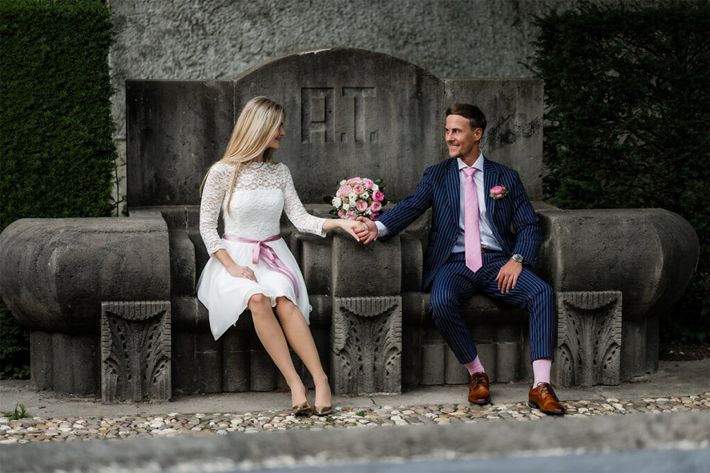 Hochzeitsfotograf Essen fotografiert eine Brautpaar auf einer großen Bank aus Stein