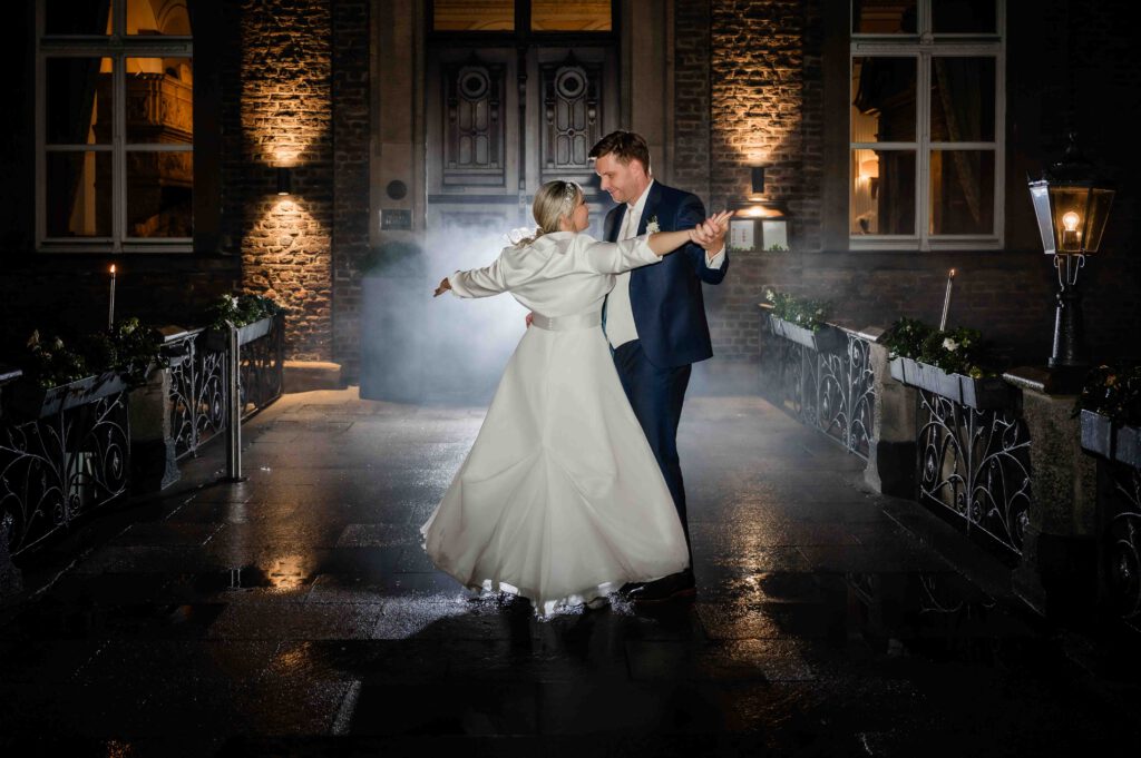 Brautpaar tanzt in die Nacht im Lampenlicht