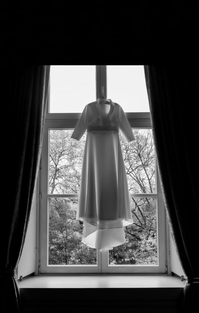 Hochzeitsfotograf Essen fotografiert ein Brautkleid das im Fenster hängt