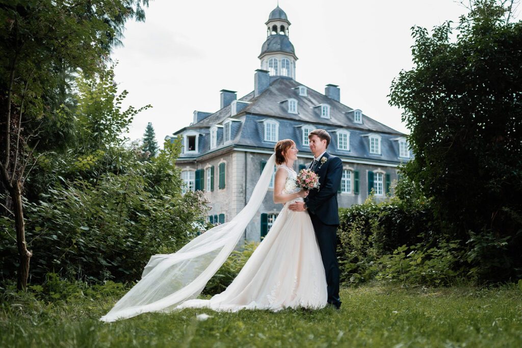 hochzeitsfotograf solingen fotografiert ein glückliches hochzeitspaar vor dem wasserschloss hackhausen