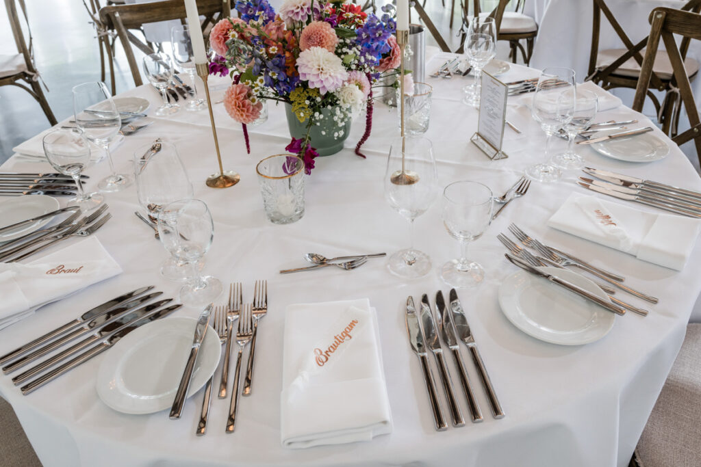 Bei unserem Kennenlerngespräch im Hauptquatier von Linke Catering in Velbert wurde uns allen schnell klar, dass es zwischen uns matcht. Die Sympathie und das Vertrauen zwischen Friederike, Martin und mir war gesetzt. Ich betone es hier gerne noch einmal. Die Chemie zwischen Brautpaar und mir muss stimmen, um ehrliche und berührende Bilder zu bekommen. Schnell rückte der große Hochzeitstag näher. Es sollte eine exklusive Sommerhochzeit mit einer besonderen freien Trauung auf dem wunderschönen Schloss Linnep sein. Was für eine romantische Hochzeitslocation zwischen Essen und Düsseldorf. Als Hochzeitsfotograf in Essen ist es immer etwas Besonderes, an solch traumhaften Orten arbeiten zu dürfen. Obwohl Martin und Friederike bereits seit zehn Jahren verheiratet sind, wollten sie die Gelegenheit nutzen, mit all ihren Freunden eine große Feier und eine freie Trauung nachzuholen. Die Zeremonie war besonders emotional, vor allem die Traurede, die der Vater der Braut hielt. Es flossen einige Freudentränen, und die Liebe zwischen den beiden war in jedem Moment spürbar. Als Hochzeitsfotograf in Essen ist es meine Leidenschaft, solche einzigartigen Augenblicke festzuhalten. Friederike und Martin arbeiten für den Catering-Service Linke, und das gesamte Team kümmerte sich mit viel Liebe um das erstklassige Abendessen sowie die Bewirtung der rund 100 Gäste. Das Highlight des Abends war das exquisite 8-Gänge-enü, das zwischen 19:30 Uhr und 23:30 Uhr serviert wurde. Aus fotografischer Sicht war es keine große Herausforderung, aber geschmacklich einfach großartig! Der Zeitplan geriet etwas ins Wanken, sodass der Mitternachtssnack vorerst verschoben wurde, da alle es kaum erwarten konnten, endlich zu tanzen. Gegen 1 Uhr nachts bin ich dann mit dem Brautpaar noch einmal nach draußen gegangen, um spektakuläre Nachtaufnahmen zu machen. Obwohl das Schloss zu diesem Zeitpunkt bereits dunkel war, genügte ein kurzer Anruf beim Schlossherren, und es erstrahlte wieder in seinen schönsten Farben. Es war eine fantastische Hochzeit an der Seite von Friederike und Martin. Vielen herzlichen Dank für das Vertrauen in meine Arbeit als Hochzeitsfotograf in Essen! Ich freue mich darauf, auch in Zukunft solche besonderen Momente festzuhalten.