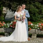 Brautpaar steht vor einem Blumenbeet