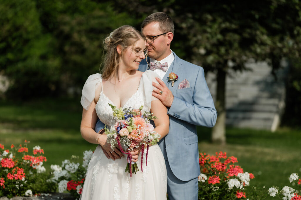Brautpaar flirtet in der Natur mit Blumen