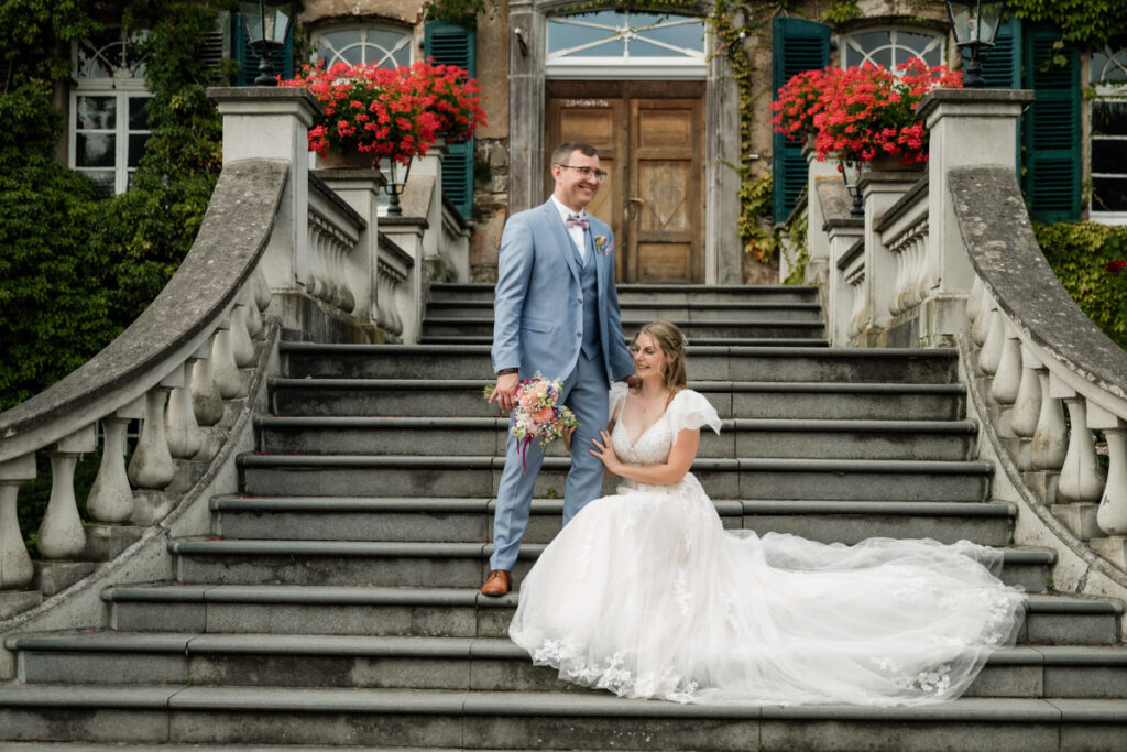 hochzeitsfotograf nrw fotografiert das Brautpaar auf der Treppe von Schloss Linnep
