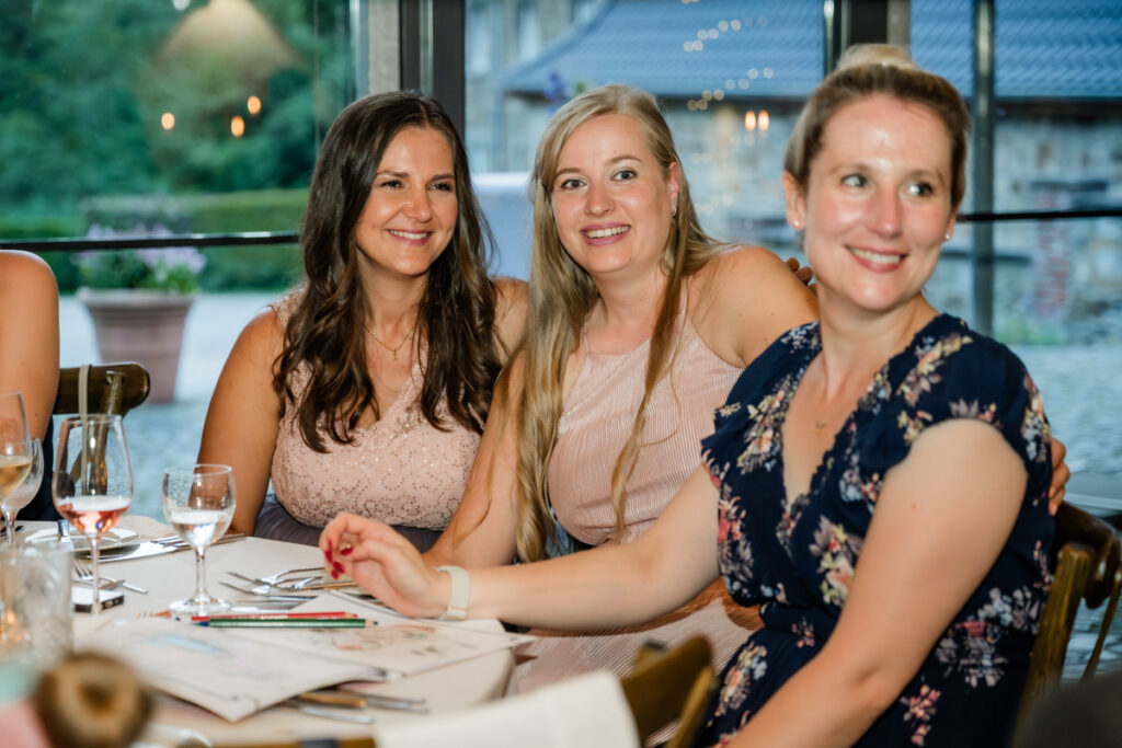 glückliche Hochzeitsgäste hören der Brautrede zu