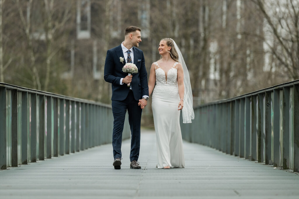 Brautpaar läuft über eine Brücke