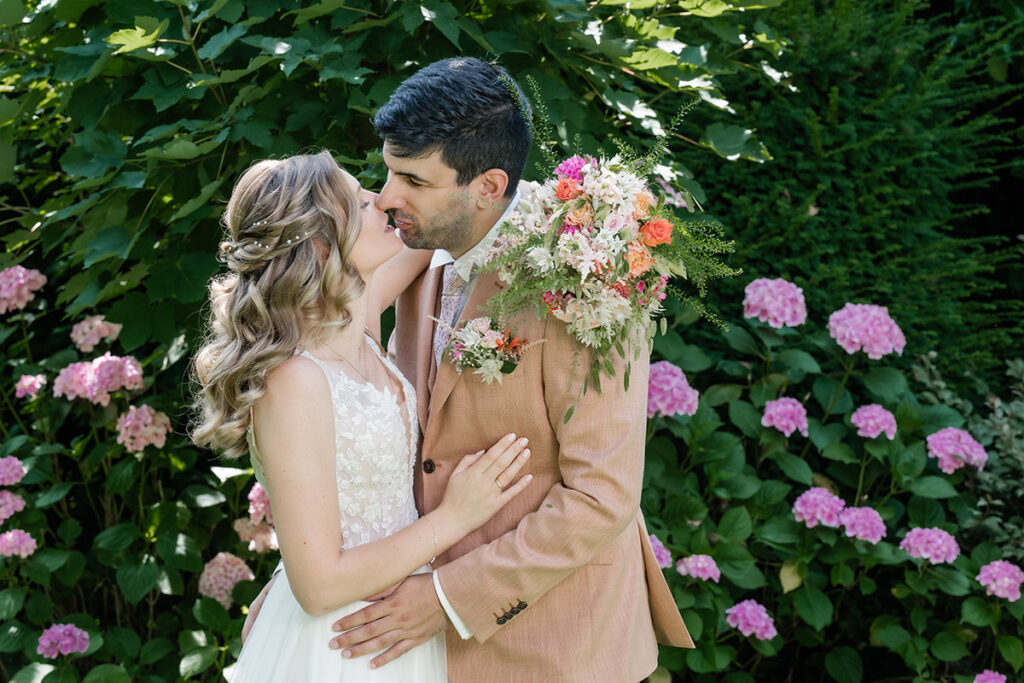 Brautpaarshooting im Garten des Romantik Hotel Neuhaus Iserlohn, Bräutigam hebt lachende Braut hoch, Hochzeitsfotografie Andreas Zabel