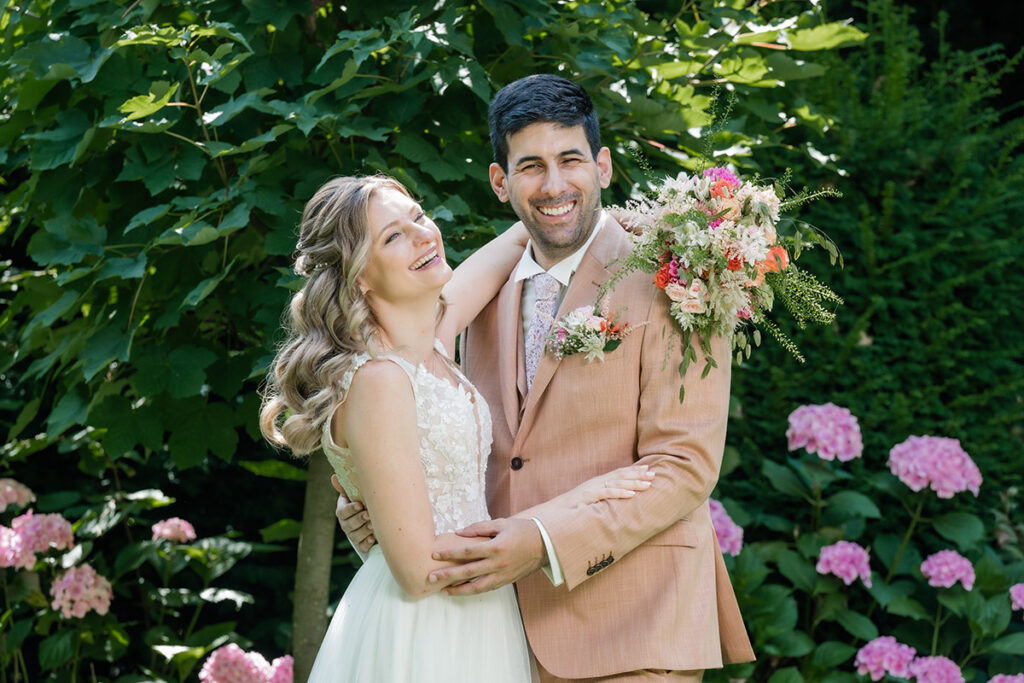 Brautpaarshooting im Garten des Romantik Hotel Neuhaus Iserlohn, Bräutigam hebt lachende Braut hoch, Hochzeitsfotografie Andreas Zabel