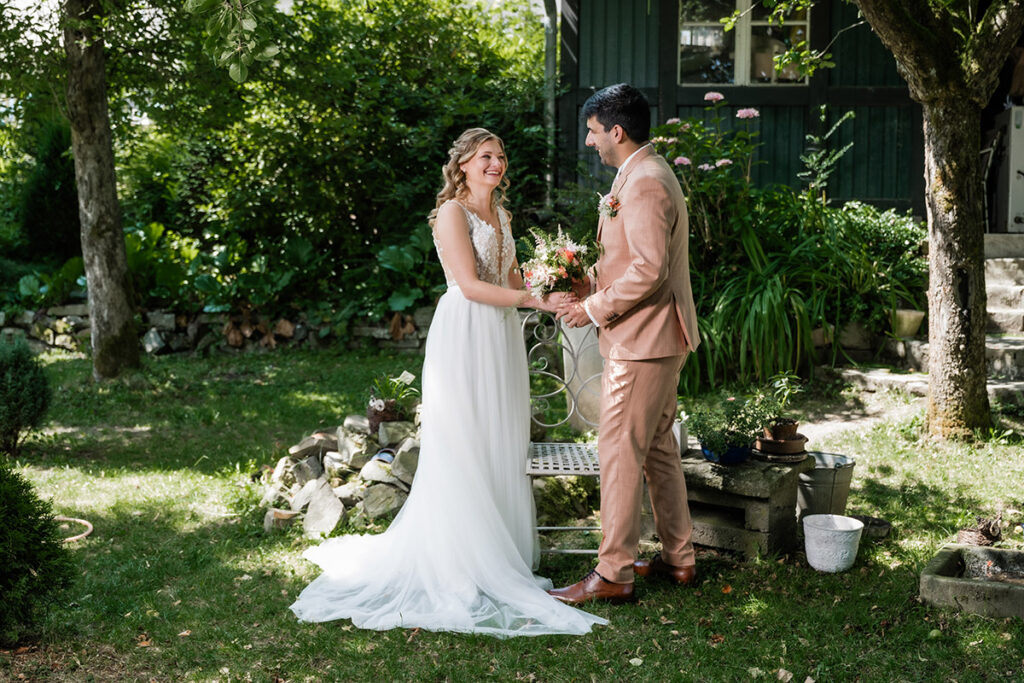 Brautpaarshooting im Garten des Romantik Hotel Neuhaus Iserlohn, Bräutigam hebt lachende Braut hoch, Hochzeitsfotografie Andreas Zabel