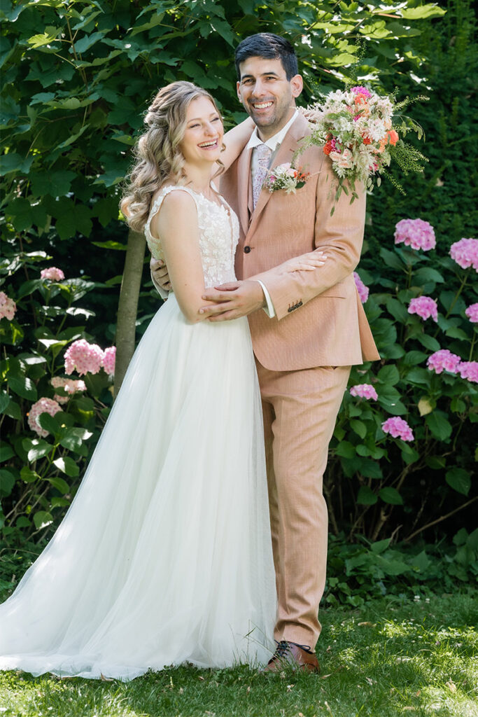 Brautpaarshooting im Garten des Romantik Hotel Neuhaus Iserlohn, Bräutigam hebt lachende Braut hoch, Hochzeitsfotografie Andreas Zabel