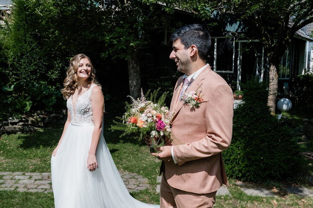 Brautpaarshooting im Garten des Romantik Hotel Neuhaus Iserlohn, Bräutigam hebt lachende Braut hoch, Hochzeitsfotografie Andreas Zabel