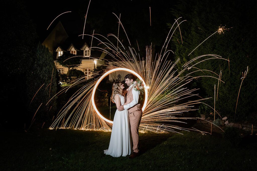 Brautpaarshooting im Garten des Romantik Hotel Neuhaus Iserlohn: Bräutigam hebt die lachende Braut hoch, Hochzeitsfotografie Andreas Zabel
