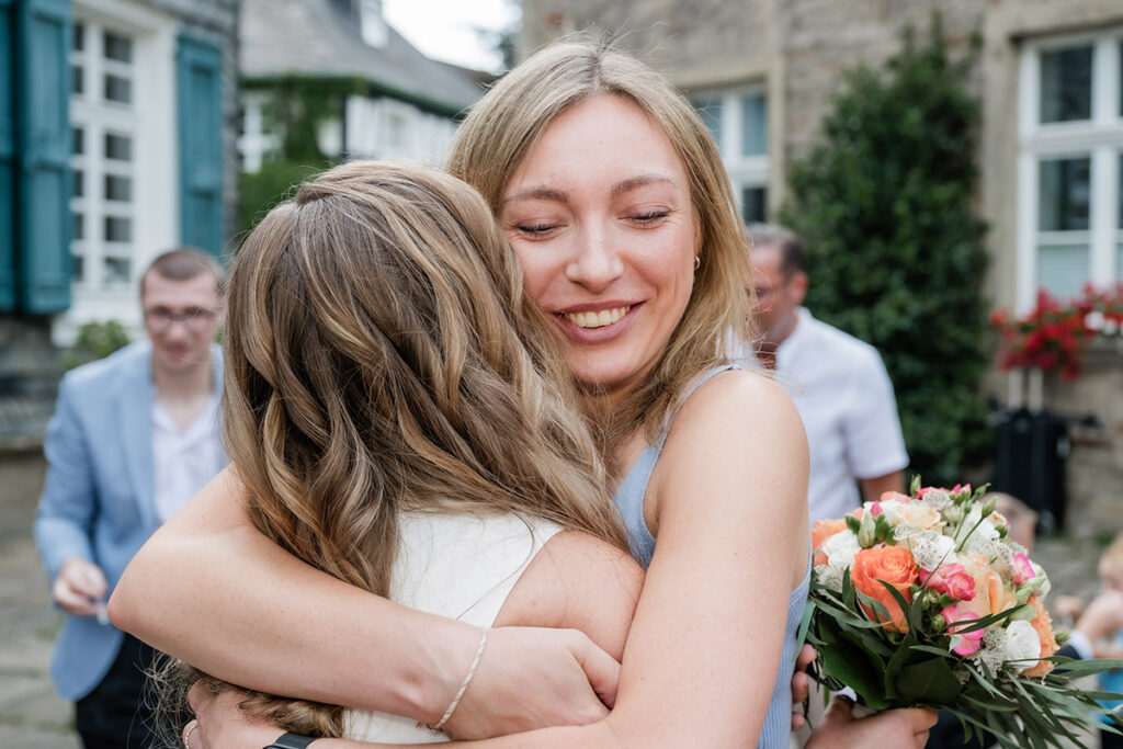 Emotionale Umarmung zwischen Braut und Hochzeitsgast nach der Trauung am Standesamt Herdecke, fotografiert von Andreas Zabel