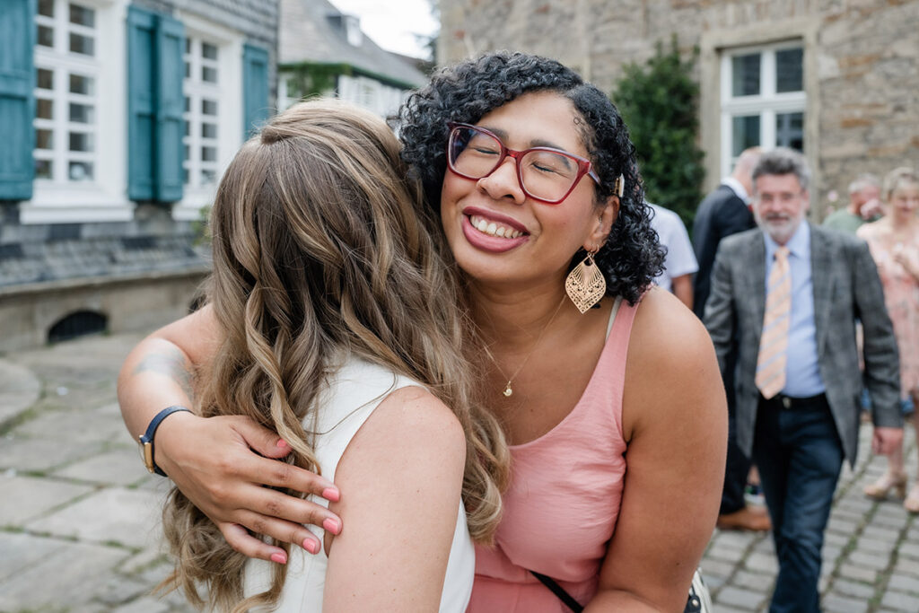 Emotionale Umarmung zwischen Braut und Hochzeitsgast nach der Trauung am Standesamt Herdecke, fotografiert von Andreas Zabel