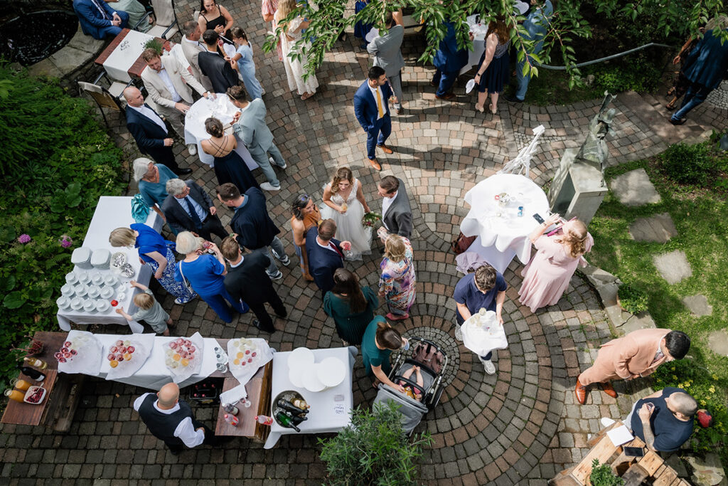 Hochzeitsempfang im stimmungsvollen Innenhof des Romantikhotels Neuhaus Iserlohn, lebendige Hochzeitsreportage von Fotograf Andreas Zabel