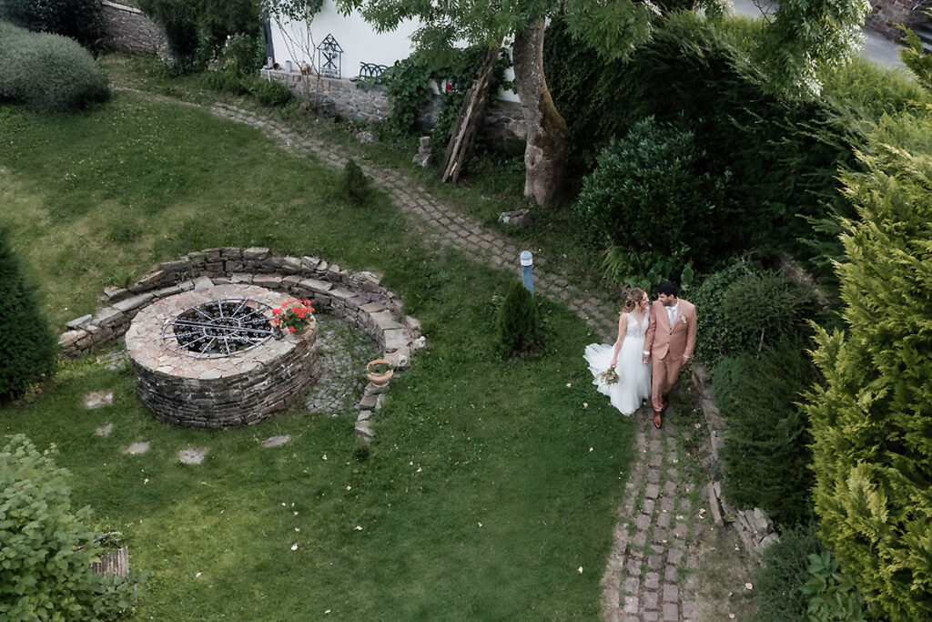 Luftaufnahme eines Brautpaares im Garten vom Romantikhotel Neuhaus in Iserlohn, fotografiert aus der Vogelperspektive von Hochzeitsfotograf Andreas Zabel