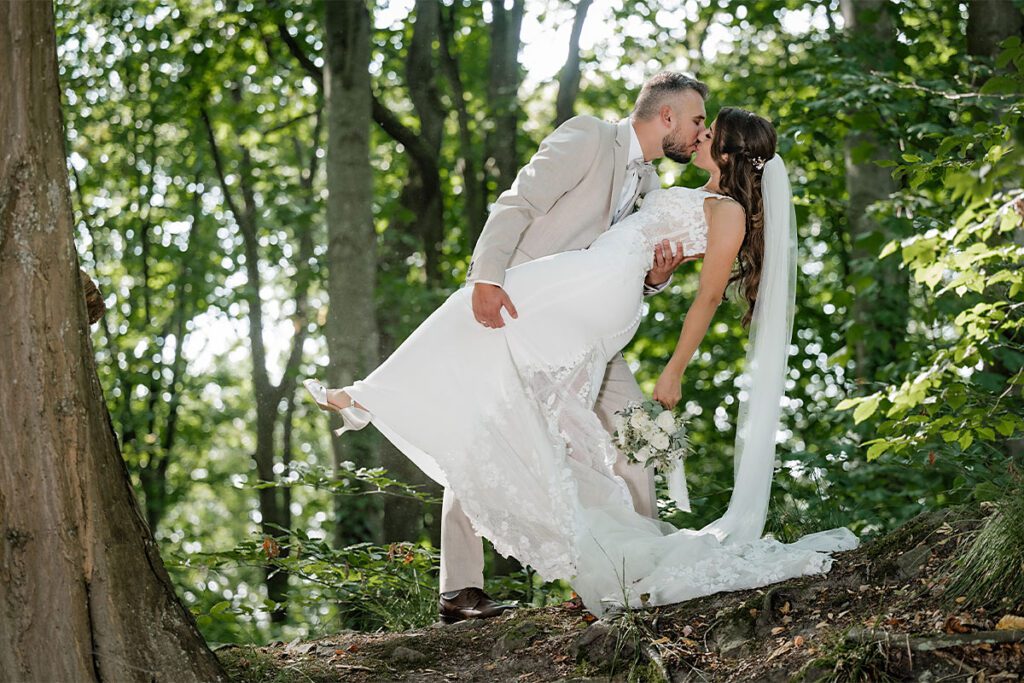 Romantischer Kuss des Brautpaares im Grünen beim Hochzeits-Shooting im Wald in Essen